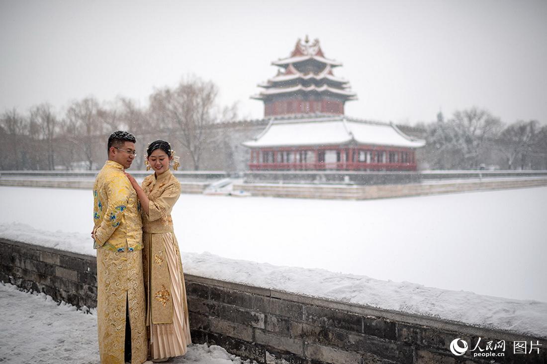 2月13日，故宫角楼前，新人在雪中拍摄婚纱照。人民网记者翁奇羽摄