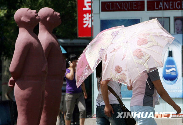 6月24日，市民撑伞走过洛阳街头。